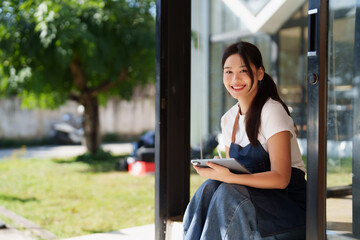 Young woman smiling while sitting with digital tablet