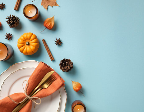 Autumn Festive Table Setting with Pumpkin Candles and Rustic Decor on Blue Background with Copy Space