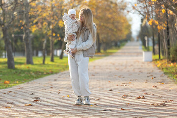 Fototapeta premium A beautiful woman walks in the park with a child 
