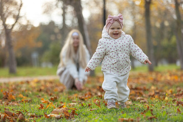 A beautiful woman walks in the park with a child 