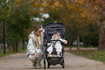 A beautiful woman walks in the park with a child 