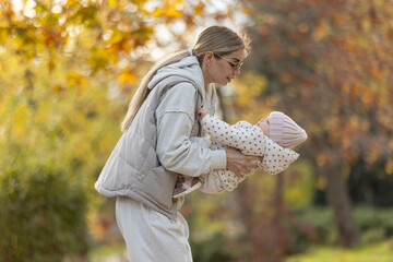 A beautiful woman walks in the park with a child 