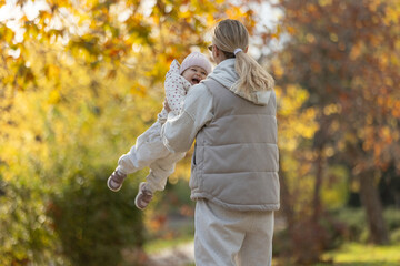 A beautiful woman walks in the park with a child 