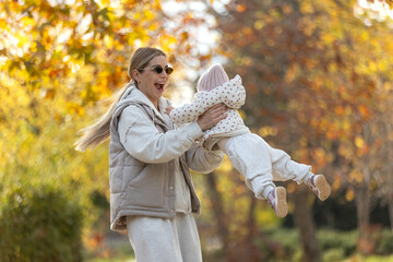 A beautiful woman walks in the park with a child 