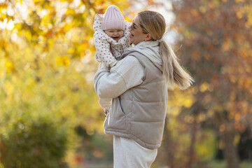 A beautiful woman walks in the park with a child 