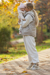 A beautiful woman walks in the park with a child 