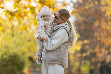 A beautiful woman walks in the park with a child 