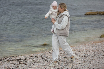 A beautiful woman walks in the park with a child 