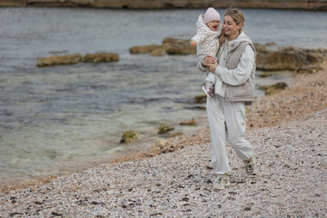 A beautiful woman walks in the park with a child 
