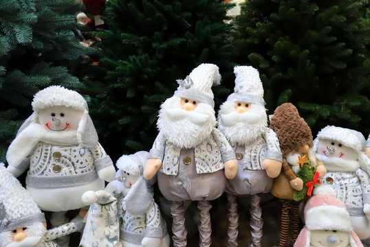 Christmas and New Year toys and decorations. Funny beautiful gnomes, snowmen, dolls under Christmas tree. Festive winter fair, sale in shopping center.