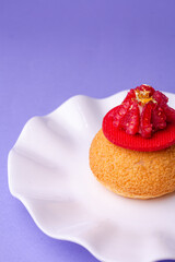 Close-up of dessert with raspberry and gold dust on purple background - sweet aesthetic