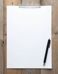 Naklejka premium Blank paper sheet on wooden table. Black pen near empty page on wood background. Clean clipboard for notes, writing, drawing. Top view angle ideal for mockups.
