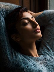 Individual in textured blue sweater leaning back with closed eyes in warm light. Ideal for editorial, wellness, lifestyle, or emotional storytelling photography themes.