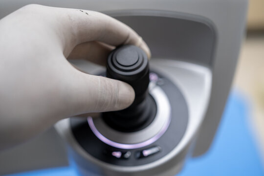 A close-up view of the ergonomic, high-precision joystick control interface used by the surgeon to manipulate and position the ZEISS Femtosecond Laser System during refractive eye surgery (SMI