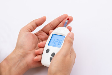 Woman's hands checking diabetes and hyperglycemia with digital blood sugar meter. Healthcare and medical concept	