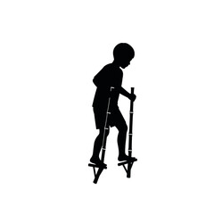 Silhouette of a young boy walking on stilts.