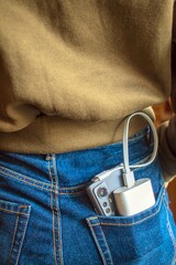 Charging the phone and external battery in the back pocket of pink jeans. Phone and portable charger in a denim pocket.