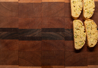 Cutting board with end grain wood and copy space, with four freshly baked biscotti cookies on the right side