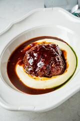 Tender meatloaf on creamy mashed potatoes, topped with savory gravy in a modern space