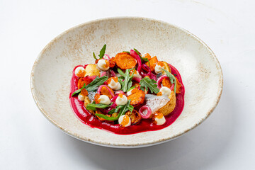 A stunning plate features roasted vegetables and vibrant sauce in a creative display