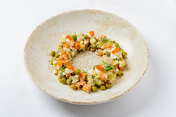 A vibrant salad made with chopped vegetables, proteins, and a drizzle of sauce, artfully arranged
