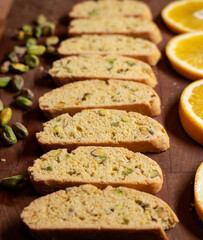 Batch of biscotti with classic italian flavors - orange and pistachio - with ingredients lining the cookies