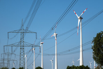 Electricity pylons with power lines and wind turbines seen in Germany