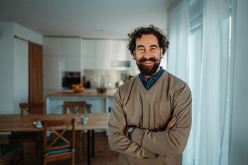 Smiling confident man with beard standing in home kitchen