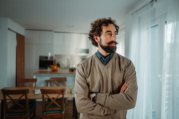 Fototapeta premium Thoughtful man with beard and mustache contemplating at home