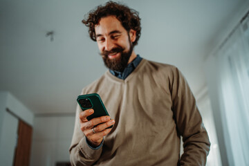 Man smiling and texting using smart phone