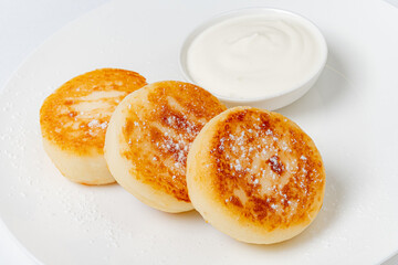 Three warm pancakes with yogurt for dipping, perfect for breakfast