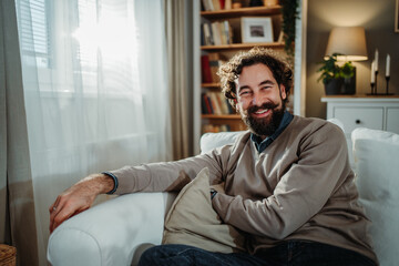 Happy man relaxing on living room couch