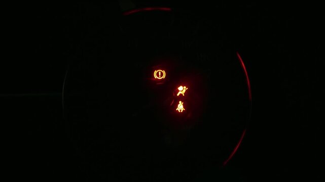 Illuminated car dashboard displaying speedometer, fuel gauge, tire pressure warning, and temperature. Indicators light up as the engine starts, creating a vivid display.