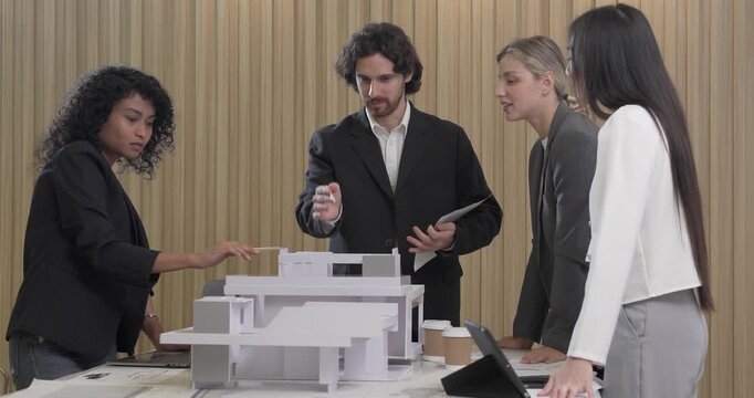 Architects and designers collaborate on an eco-friendly building project, discuss sustainable design elements and 3D architectural model. Planning energy-efficient solutions to reduce carbon footprint
