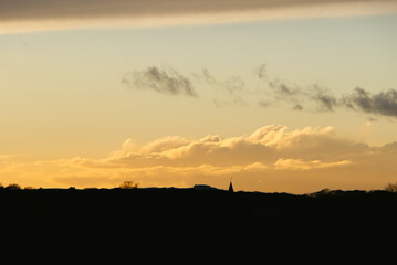 sunset with silhouette landscape and spire