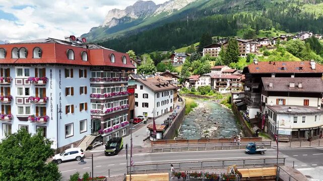 15 july 2024, Moena, Italy. Forward drone flight, aerial above Avisio river in centre of Moena in Val di Fassa, beautiful Italian Dolomites during sunny summer day. Colorful houses. Beautiful travel d