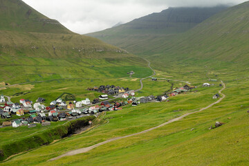 Gjógv village surrounded by lush green fields.