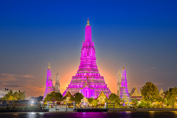 Fototapeta premium 26 November 2025 Beautiful Sunset colours of Thai Temple Wat Arun on Chao Phraya River in BKK Bangkok Thailand. The magic colourful neon light display on the temple at sunset is magical.