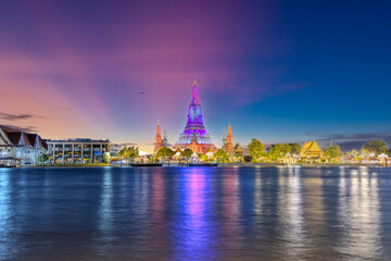 Obraz premium 26 November 2025 Beautiful Sunset colours of Thai Temple Wat Arun on Chao Phraya River in BKK Bangkok Thailand. The magic colourful neon light display on the temple at sunset is magical.