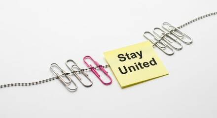 Paperclips linked supporting Stay United note on white background