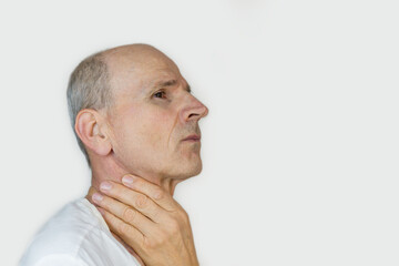 Bold senior man is holding his throat. Cold or thyroid gland health concept