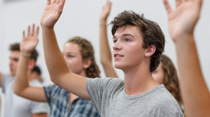 Young man raising hands in classroom setting.