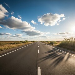 A Long Asphalt Road Stretching Through a Wide Open Landscape Under a Sunny Sky