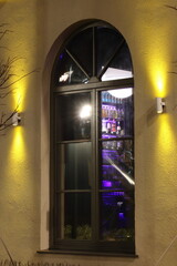 A view through a window of bottles of drinks on illuminated shelves
