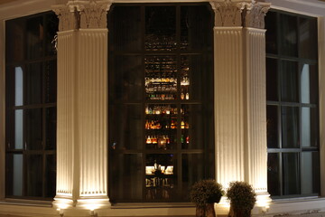 A view through a window of bottles of drinks on illuminated shelves
