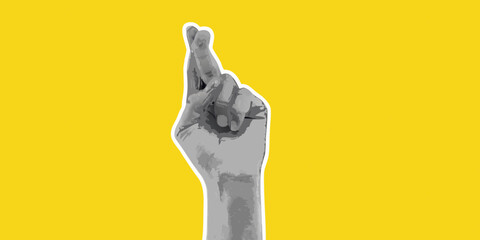 Fototapeta premium Fingers crossed hand gesture on a bright yellow background for good luck