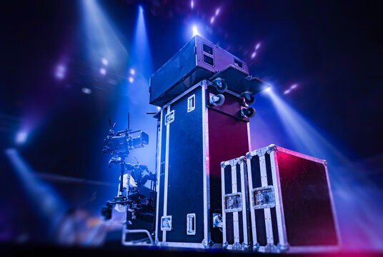 Stage equipment setup prepares professional audio and video gear in protective cases, supporting concert production, lighting arrangements and technical readiness for live events.