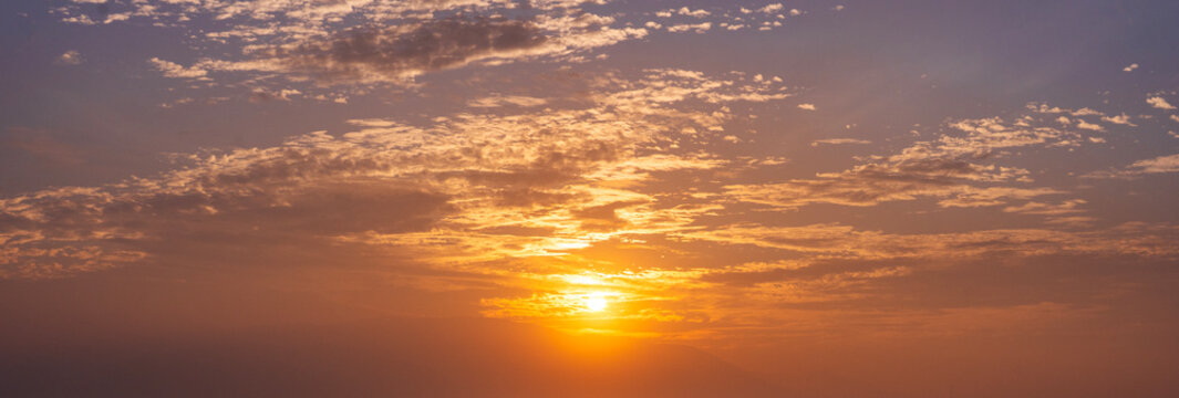 Bright sunrise sky background with clouds.