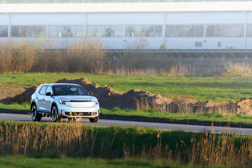 Fototapeta premium Electric car with driver on rural drive