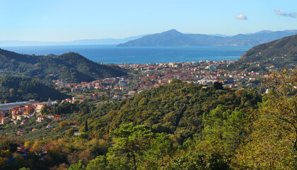 Obraz premium Traditional buildings, mountain houses by sea. Nature and architecture of Liguria. Blue skies, clouds, backdrop for design.